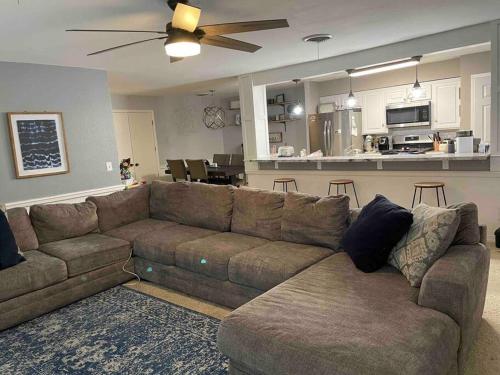 a living room with a brown couch and a kitchen at Large open space for family fun! in Amarillo