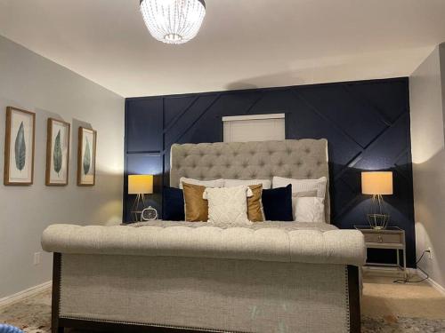 um quarto com uma cama grande e uma cabeceira azul em Large open space for family fun! em Amarillo