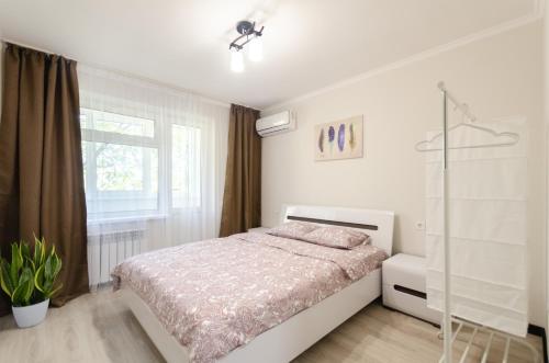a white bedroom with a bed and a window at ARTAL Apartment on Obolonskaya Square 1 in Kyiv