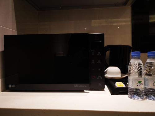 two bottles of water are sitting next to a microwave at دار ود للشقق المخدومة Dar Wed in Jeddah