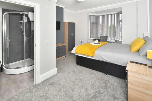 um quarto com uma cama grande e um chuveiro em Townhouse @ Bucknall New Road Stoke em Hanley