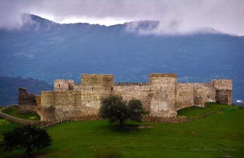 un antiguo castillo con una montaña en el fondo en Alojamiento Mª Carmen, en El Real de la Jara