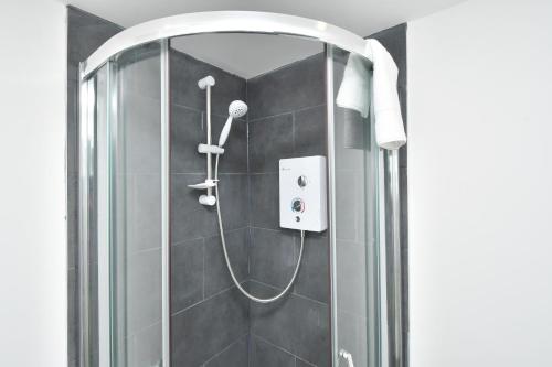 a shower with a glass door in a bathroom at Townhouse @ Bucknall New Road Stoke in Hanley