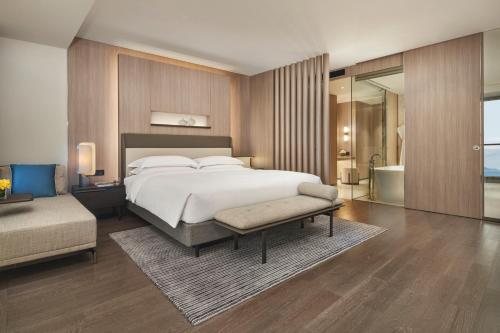 a bedroom with a large bed and a bathroom at Intercontinental Shenzhen Dameisha Resort by IHG in Shenzhen