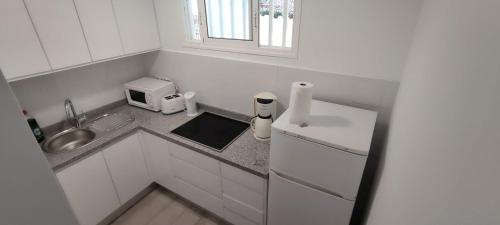 una pequeña cocina con fregadero y microondas en Apartamentos Europa - Playa del Inglés - Yumbo en San Bartolomé