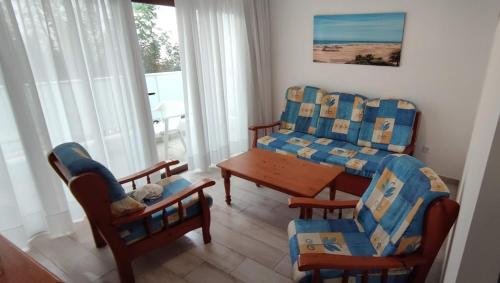 sala de estar con 2 sillas y mesa en Apartamentos Europa - Playa del Inglés - Yumbo, en San Bartolomé