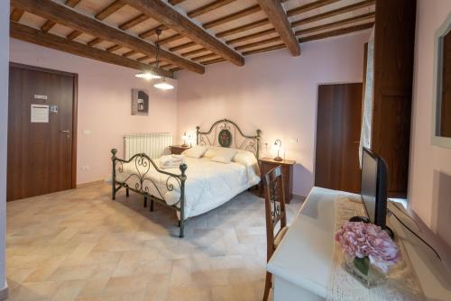 a bedroom with a bed and a desk with a television at Albergo La Loggia di San Martino in Gualdo Tadino
