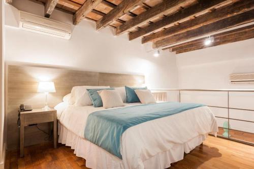a bedroom with a large bed in a room with wooden ceilings at San Telmo Suites in Buenos Aires