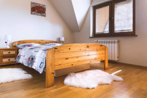 - une chambre avec un lit en bois et 2 oreillers blancs dans l'établissement Apartament Góry i Doliny, à Łapszanka