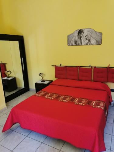 Un dormitorio con una cama roja con una colcha roja. en GIGIOTTO, en Siracusa