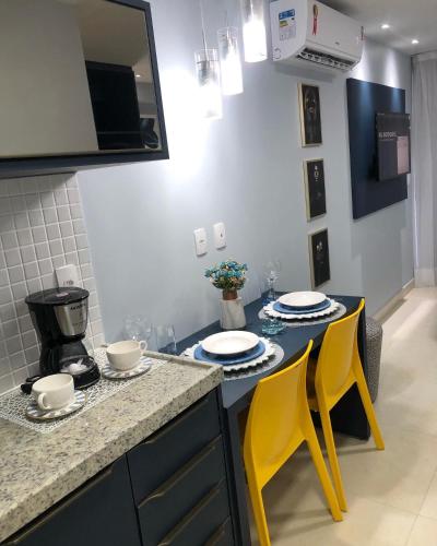 a kitchen with two yellow chairs and a counter at Apart hotel- FLAT no melhor do Manaíra 401 in João Pessoa