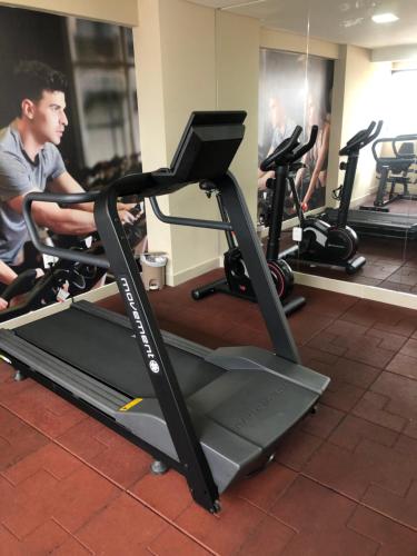 Ein Mann, der in einem Fitnessstudio auf einem Laufband trainiert. in der Unterkunft Apart hotel- FLAT no melhor do Manaíra 401 in João Pessoa