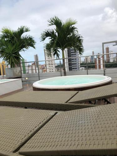 a pool on the roof of a building with palm trees at Apart hotel- FLAT no melhor do Manaíra 401 in João Pessoa