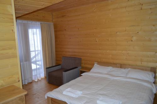 a bedroom with a white bed and a chair at Біла хата in Iltsi