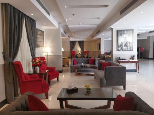 a living room with couches and red chairs at دار ود للشقق المخدومة Dar Wed in Jeddah