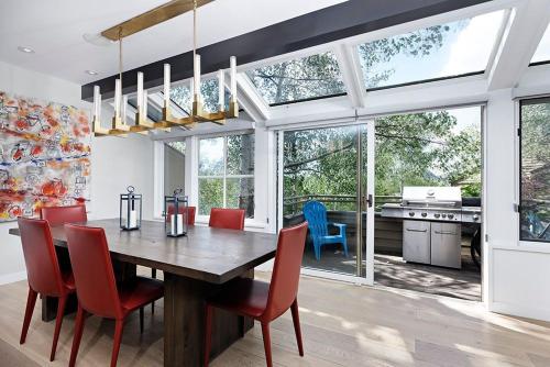 a dining room with a wooden table and red chairs at New Listing West End Jewel - Steps to bus to 4 ski areas 4860 in Aspen