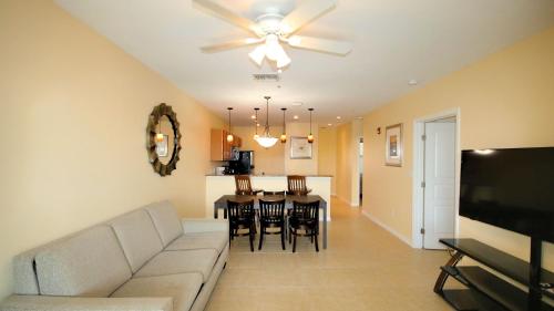 a living room and dining room with a couch and a ceiling fan at John's Pass Hotel - Fully Remote Check In in St Pete Beach