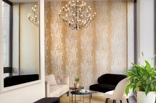 a living room with a couch and a chandelier at Hôtel des Ducs in Dijon