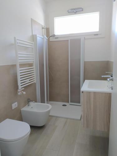 uma casa de banho com um chuveiro, um WC e um lavatório. em Jesolo Appartamenti F2 - Coral Red em Lido di Jesolo