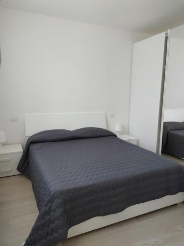 ein Schlafzimmer mit einem Bett mit einer schwarzen Bettdecke in der Unterkunft Jesolo Appartamenti F2 - Coral Red in Lido di Jesolo