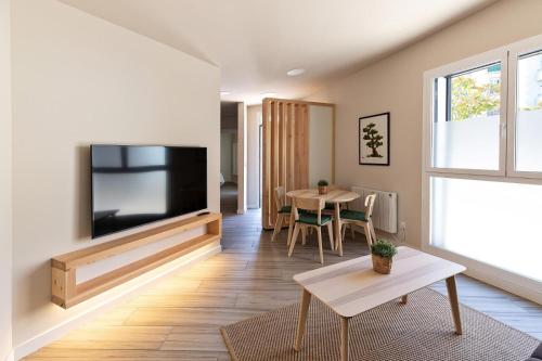 a living room with a flat screen tv and a table at A TU VERA VUT-09/298 in Burgos