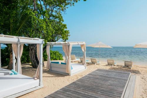 a wedding ceremony on the beach with two beds and umbrellas at Iberostar Selection Rose Hall Suites - All Inclusive in Montego Bay