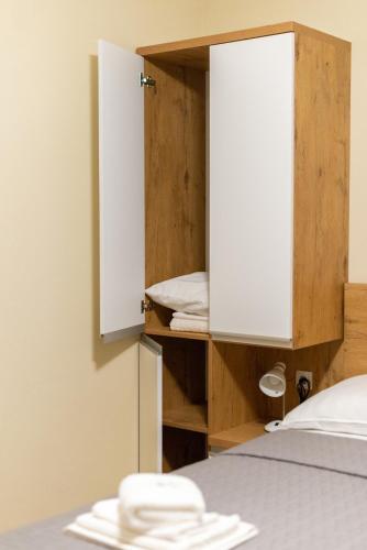 a room with a bed and a cabinet with towels at Sobe Mili Ozren in Doboj