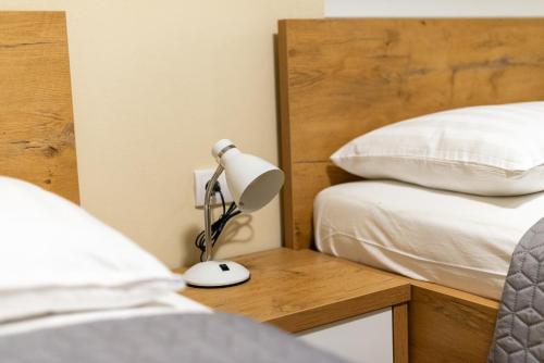a lamp on a table next to two beds at Sobe Mili Ozren in Doboj