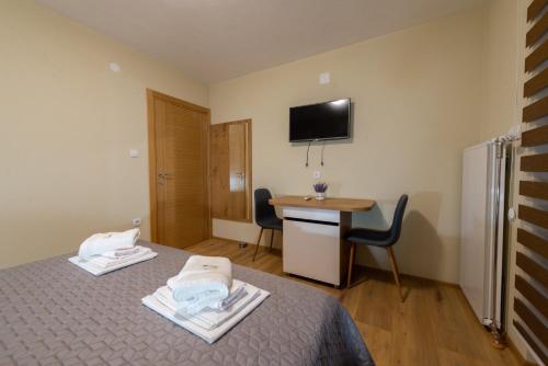 a room with a bed and a desk and a television at Sobe Mili Ozren in Doboj