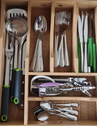 a wooden drawer with silver utensils in it at Lettu di Ita - Spectacular Gallura Stazzu with sea view and pool in Santa Teresa Gallura