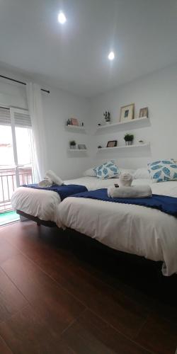 two beds in a white room with at Apartamento Madreselva 36 in Granada