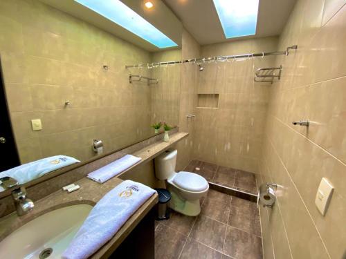 y baño con bañera, aseo y lavamanos. en Hotel Marbella Chico, en Bogotá
