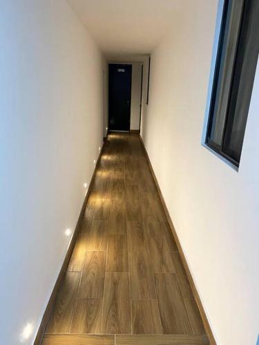 an empty hallway with a hallway leading to a black door at Hotel Olé in Monterrey