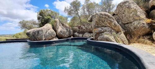 a pool of water with large rocks in it at Lettu di Ita - Spectacular Gallura Stazzu with sea view and pool in Santa Teresa Gallura