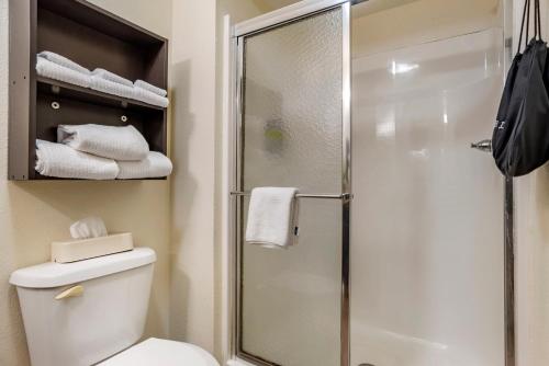a bathroom with a shower and a toilet and towels at Candlewood Suites Alabaster by IHG in Alabaster