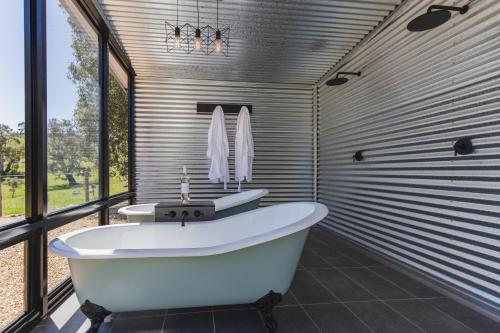 La salle de bains est pourvue de 2 lavabos et d'une baignoire. dans l'établissement Brockenchack Retreat Bed & Breakfast, à Mount McKenzie