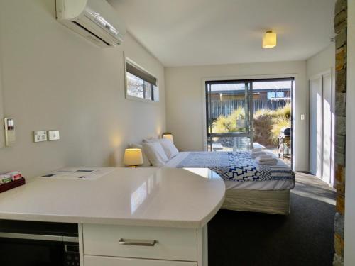 a bedroom with two beds and a view of a patio at Little Rock in Lake Tekapo