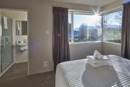 a bedroom with a bed and a sink and a window at Connemara Retreat - Lake Tekapo in Lake Tekapo