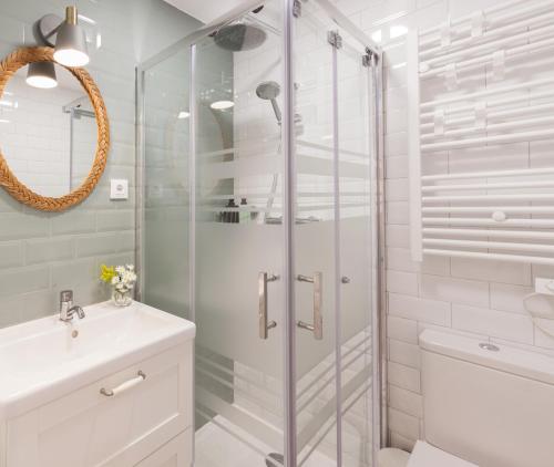 a white bathroom with a shower and a sink at Madrid Comfort Suites in Madrid