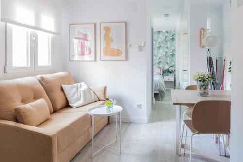 uma sala de estar com um sofá e uma mesa em Dolphin Rentals Hortaleza em Madrid