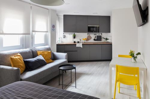 uma sala de estar com um sofá e uma cozinha em Dolphin Rentals Hortaleza em Madrid