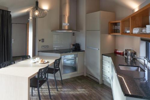 a kitchen with a table and chairs in a kitchen at Designer Cabin - Lake Tekapo in Lake Tekapo