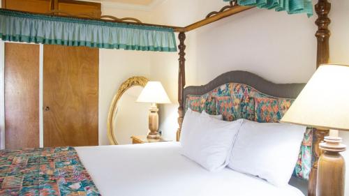 a bedroom with a bed with a canopyved bed sidx sidx sidx at Holidays At Holiday Heaven in Runaway Bay