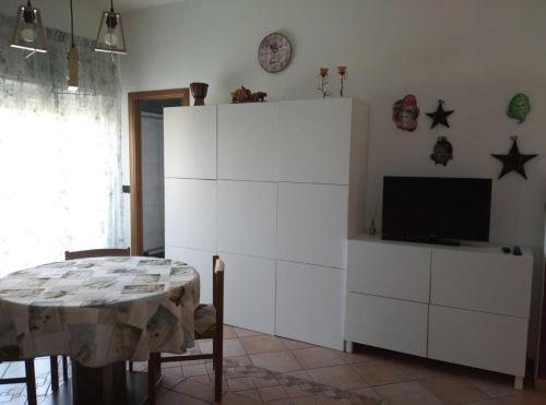ein Wohnzimmer mit einem weißen Schrank und einem Tisch in der Unterkunft Casa Ada in Bollate