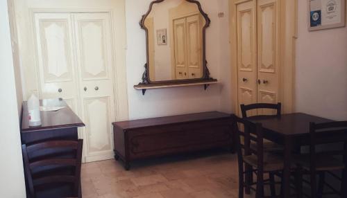 a dining room with a table and a mirror at Accogliente Dimora in Putignano