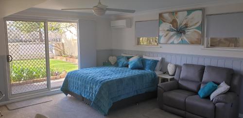a bedroom with a bed and a couch and a window at Bella Vista B @ B in North Haven