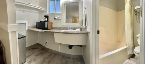 La salle de bains est pourvue d'un lavabo et de toilettes. dans l'établissement Americas Inn & Suite, à Shoreline