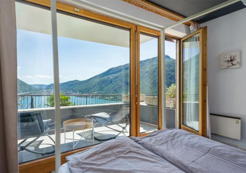 a bedroom with a bed and a balcony with a view at Casa Belvedere in Rovio