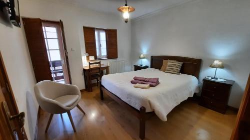 a bedroom with a bed and a chair and a desk at Apimonte Casa do Pascoal - PN Montesinho in Bragança