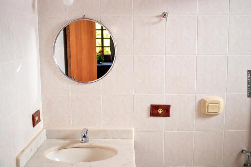 a bathroom with a mirror and a sink at Chalés Paradiso in Nova Friburgo
